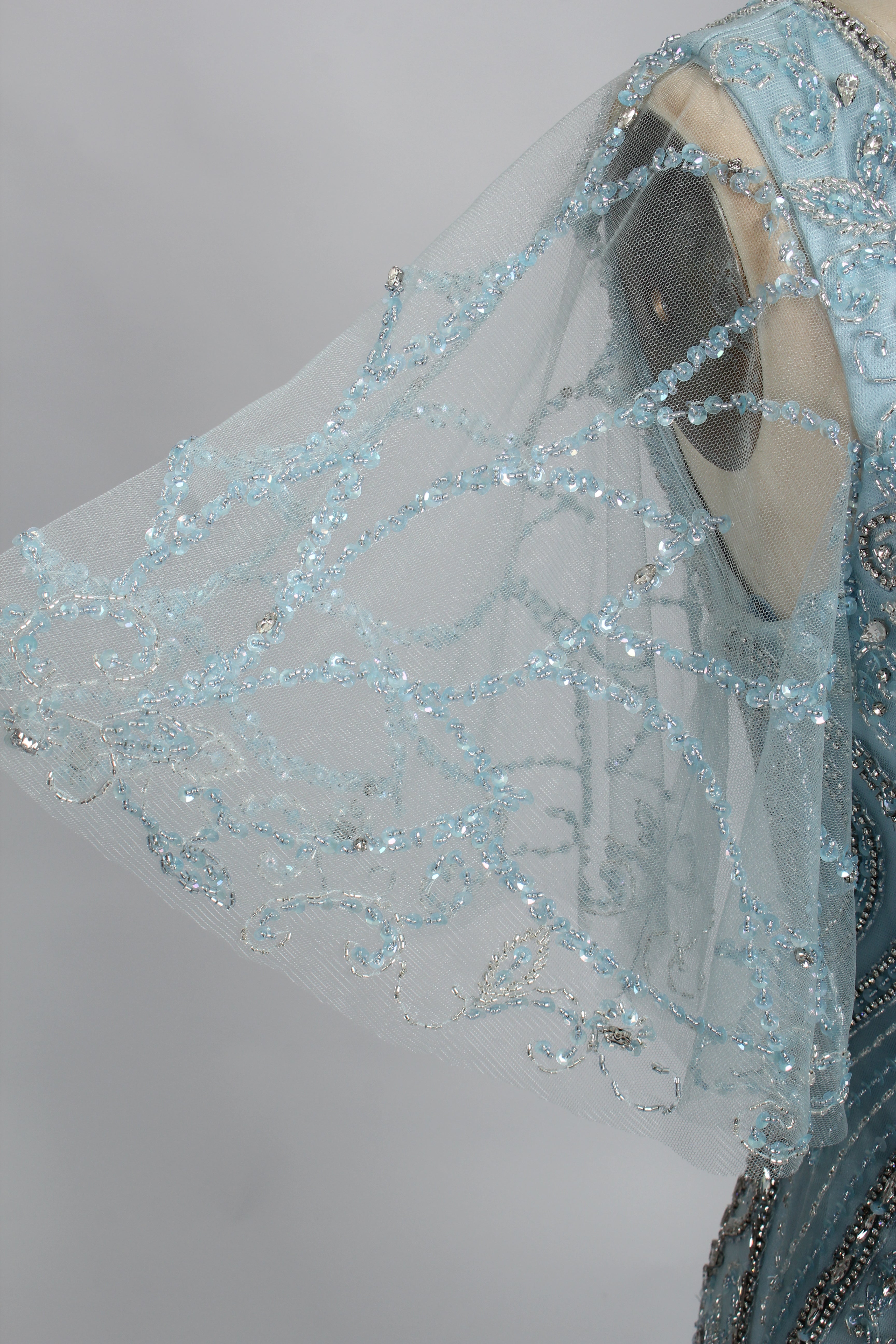 Light blue beaded lace V-neck overlay with sheer fabric and dangling beadwork detail