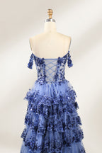 Photograph of a mannequin displaying a strapless, multi-layered, light blue tulle gown adorned with intricate floral embroidery. The gown has an off-shoulder neckline and a fitted bodice, cascading into voluminous, ruffled tiers. The background is plain white, highlighting the dress's delicate details. The mannequin is marked with the number "4" on its torso.6