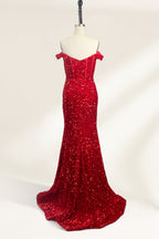 A photograph of a mannequin showcasing an off-the-shoulder, floor-length red sequin gown with a plunging V-neckline. The dress has a fitted bodice and a flared skirt, creating a glamorous, elegant appearance. The mannequin stands against a plain white background, emphasizing the dress's vibrant color and intricate details.02