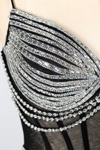 A mannequin showcases a black gown with silver beading. It has thin straps, a sheer bodice, and a high side slit. The geometric beading pattern adds glamour, making it perfect for formal events like galas or proms, radiating sophistication.5