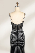 A mannequin showcases a black gown with silver beading. It has thin straps, a sheer bodice, and a high side slit. The geometric beading pattern adds glamour, making it perfect for formal events like galas or proms, radiating sophistication.4