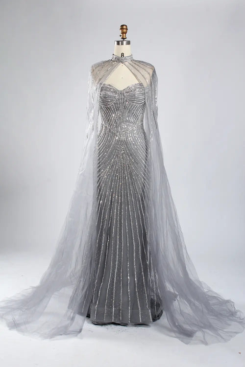 Silver-gray beaded evening gown with sheer cape sleeves and flowing open-back drape
