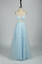 A woman stands against a light background, wearing a blue tulle gown. It features thin straps, a deep V - neckline, intricate floral appliqués with sequins on the bodice, and a high side slit. The voluminous tulle skirt creates a romantic and glamorous look, perfect for formal events like proms or weddings.7