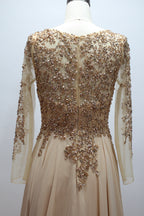 Back view of champagne sequin lace bodice dress with long sheer sleeves and embellished waist